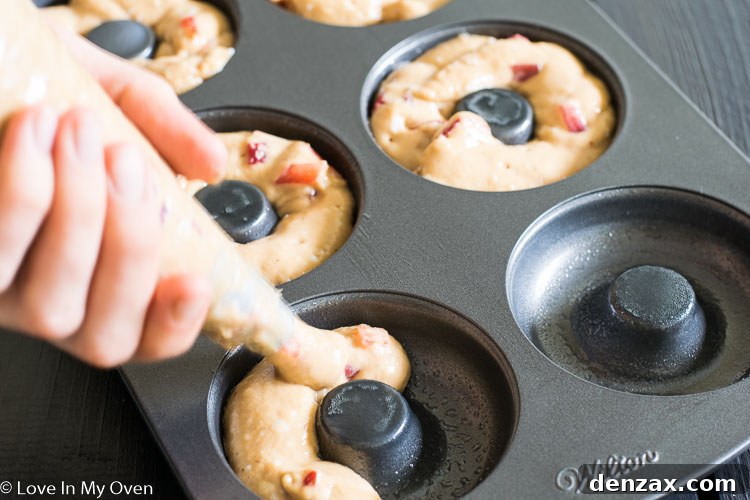 piping donut batter into pan
