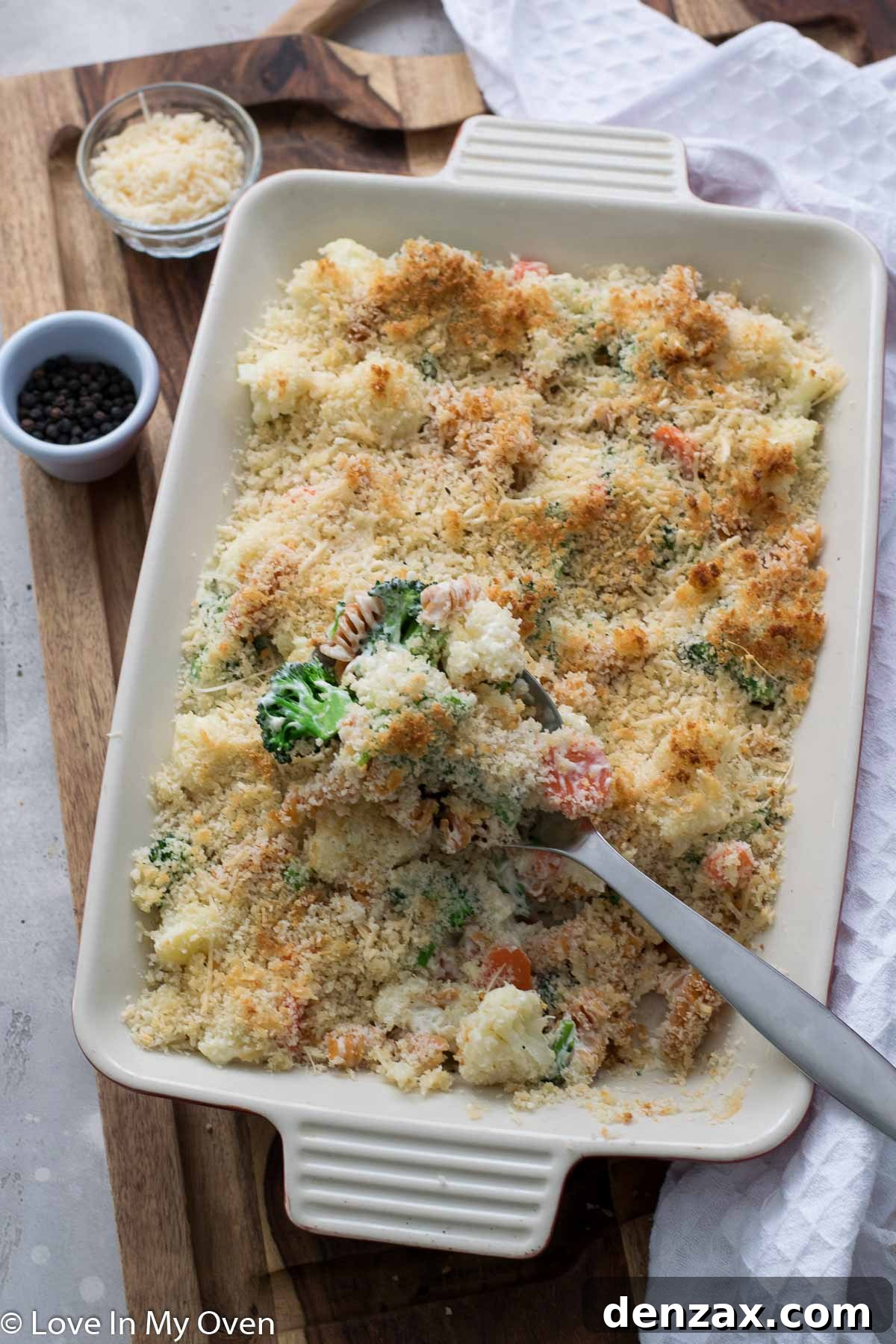 Close-up of a bubbling creamy vegetable casserole with a golden-brown cheesy crust, ready to be served.