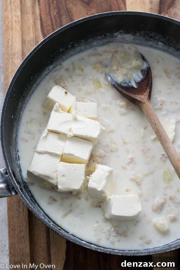 Onions sautéing in butter in a saucepan, turning translucent, for the creamy sauce base.