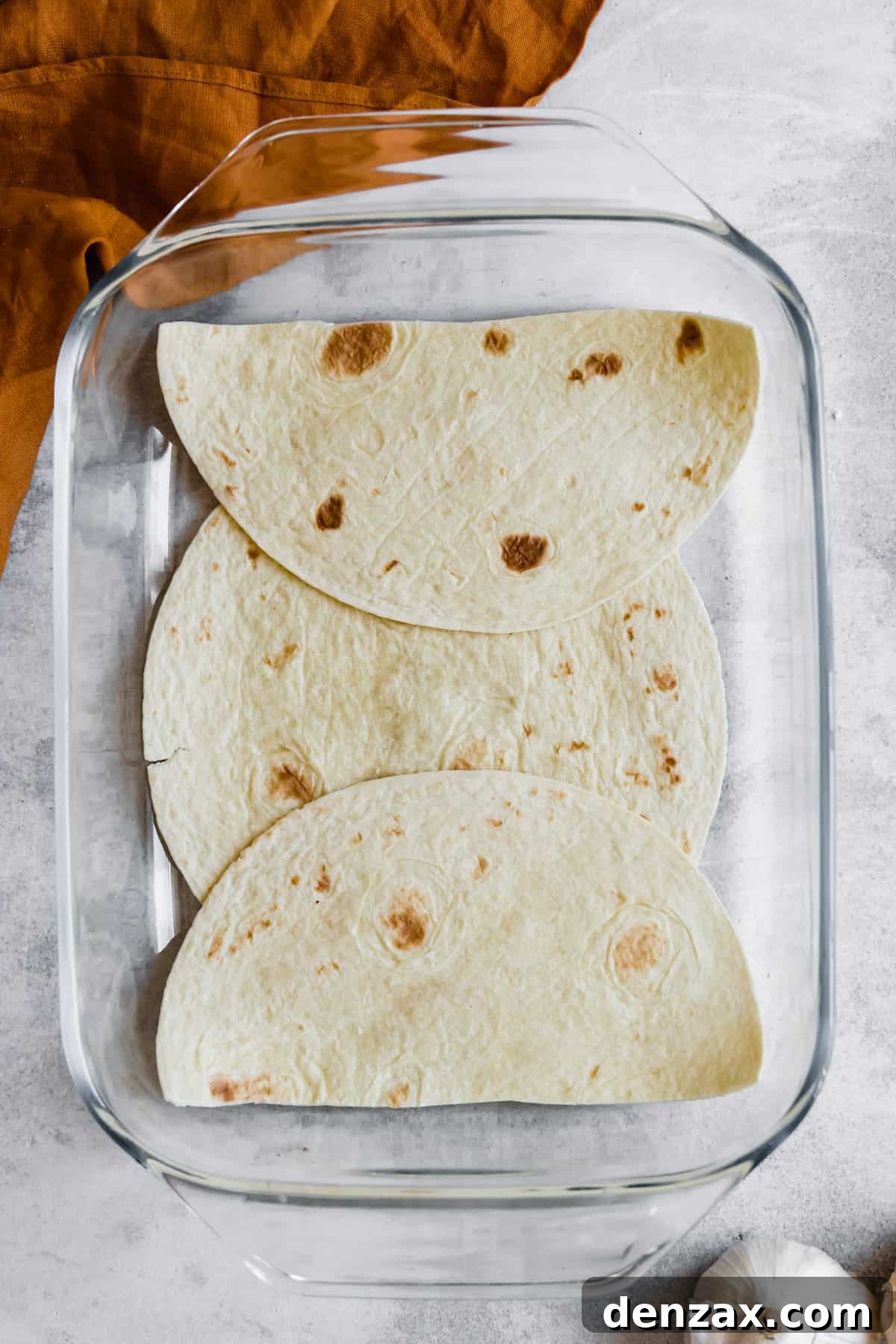 A Layer of Soft Corn Tortillas in a Glass Baking Dish