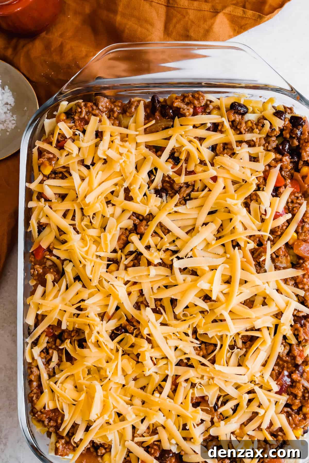 Layered, Unbaked Mexican Lasagna with Shredded Cheddar Cheese on Top