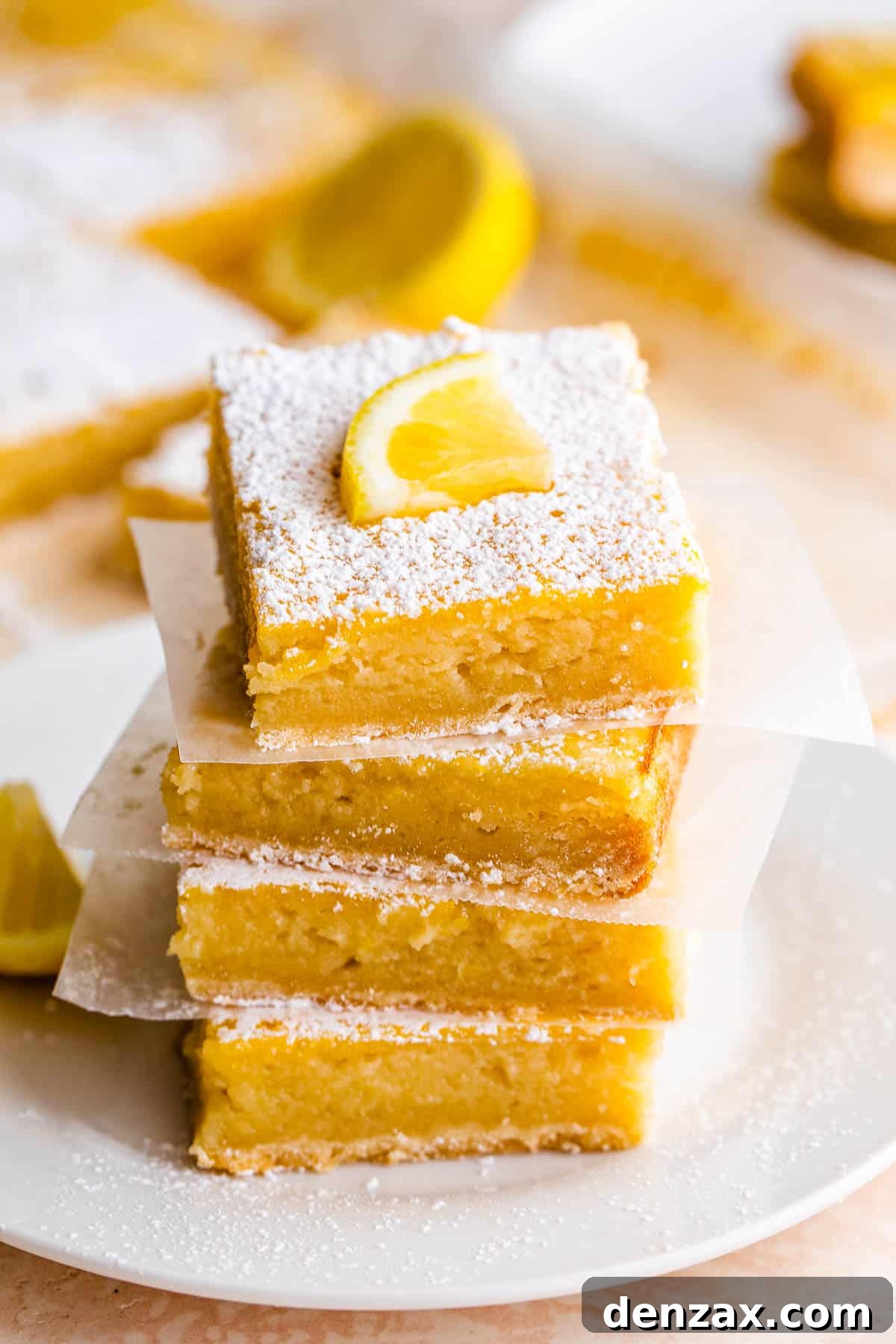 Stacked lemon bars with powdered sugar and lemon slice garnish