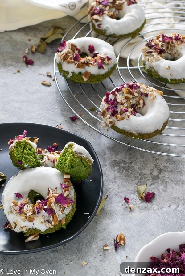 Stack of iced Green Monster Donuts with sprinkles.