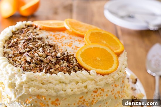 Close-up of a slice of orange carrot cake, showing moist layers and frosting.