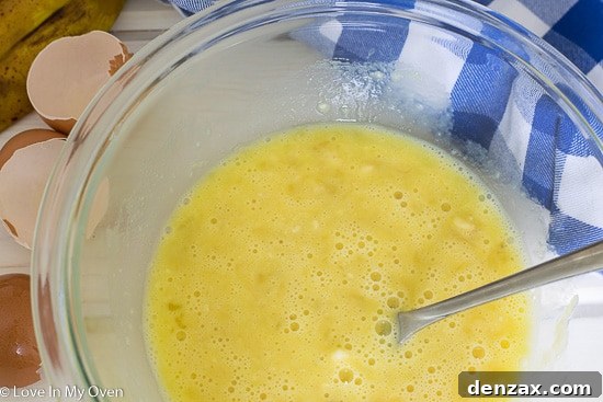 Whisking mashed banana and eggs together to form pancake batter