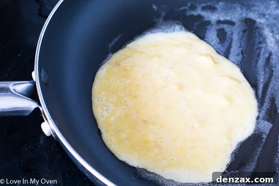 Frying two-ingredient banana egg pancakes in a pan with butter