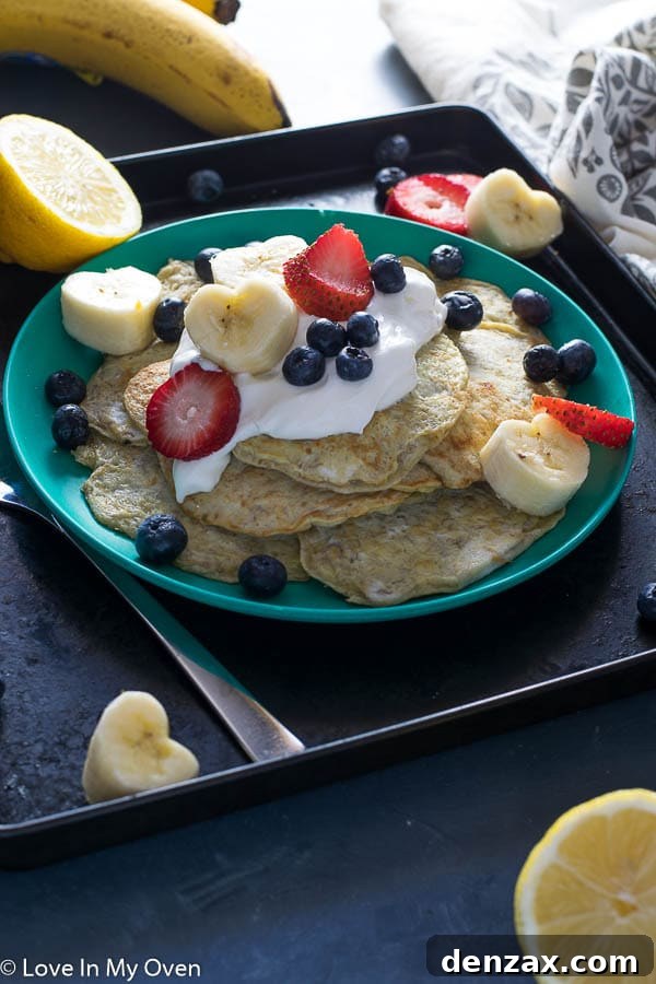 A child's hands reaching for two-ingredient banana egg pancakes, perfect for baby-led weaning