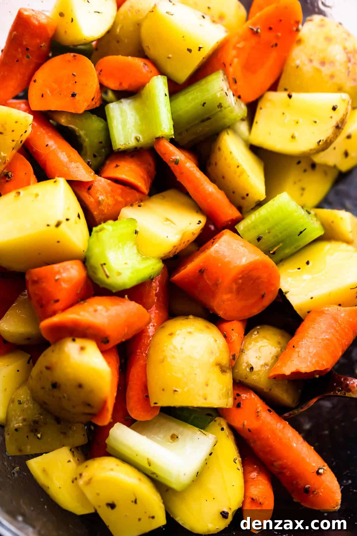 Herb-Crusted Pork Loin and Roasted Root Vegetables 5 glass bowl with chopped pieces of carrots, celery, and potatoes