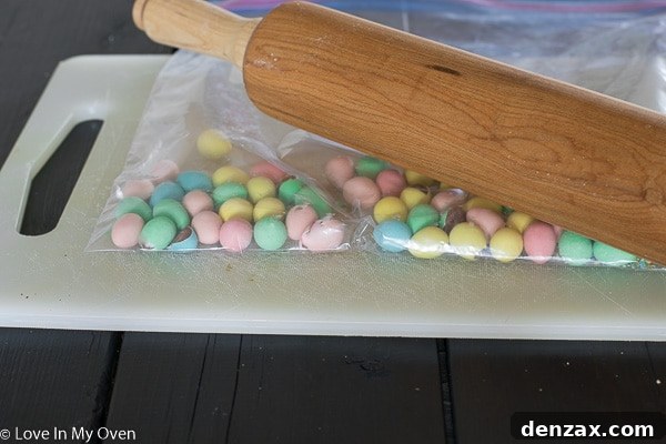 Crushing mini eggs in a freezer bag with a rolling pin for a skillet cookie recipe