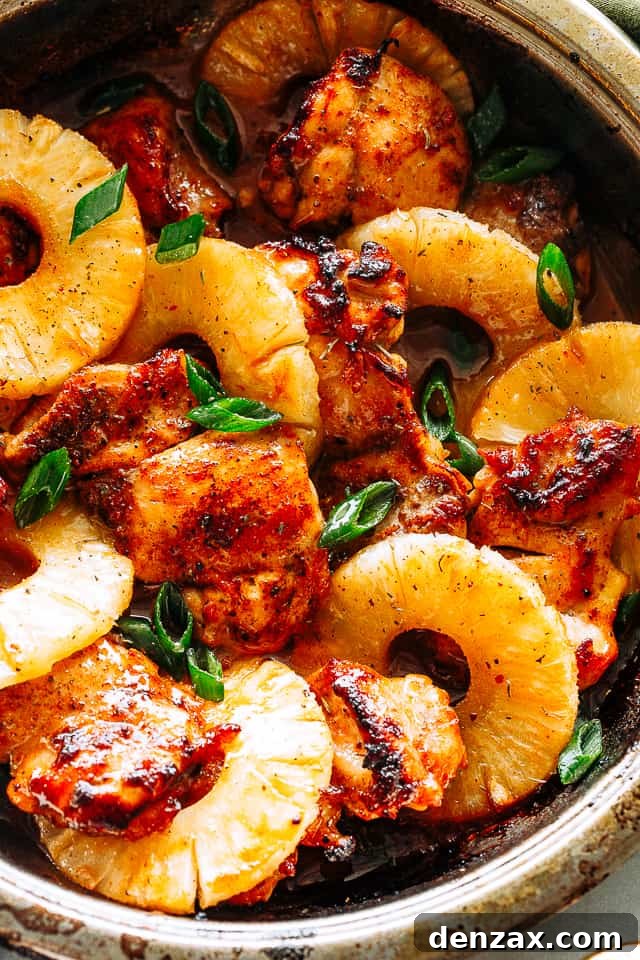Pineapple barbeque chicken thighs, glistening with sauce and topped with fresh green onions, ready to serve.
