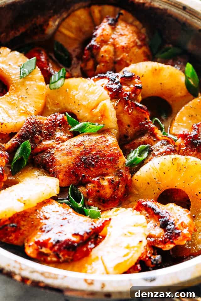 A perfectly cooked plate of pineapple barbecue chicken thighs, garnished with fresh herbs, ready for serving.