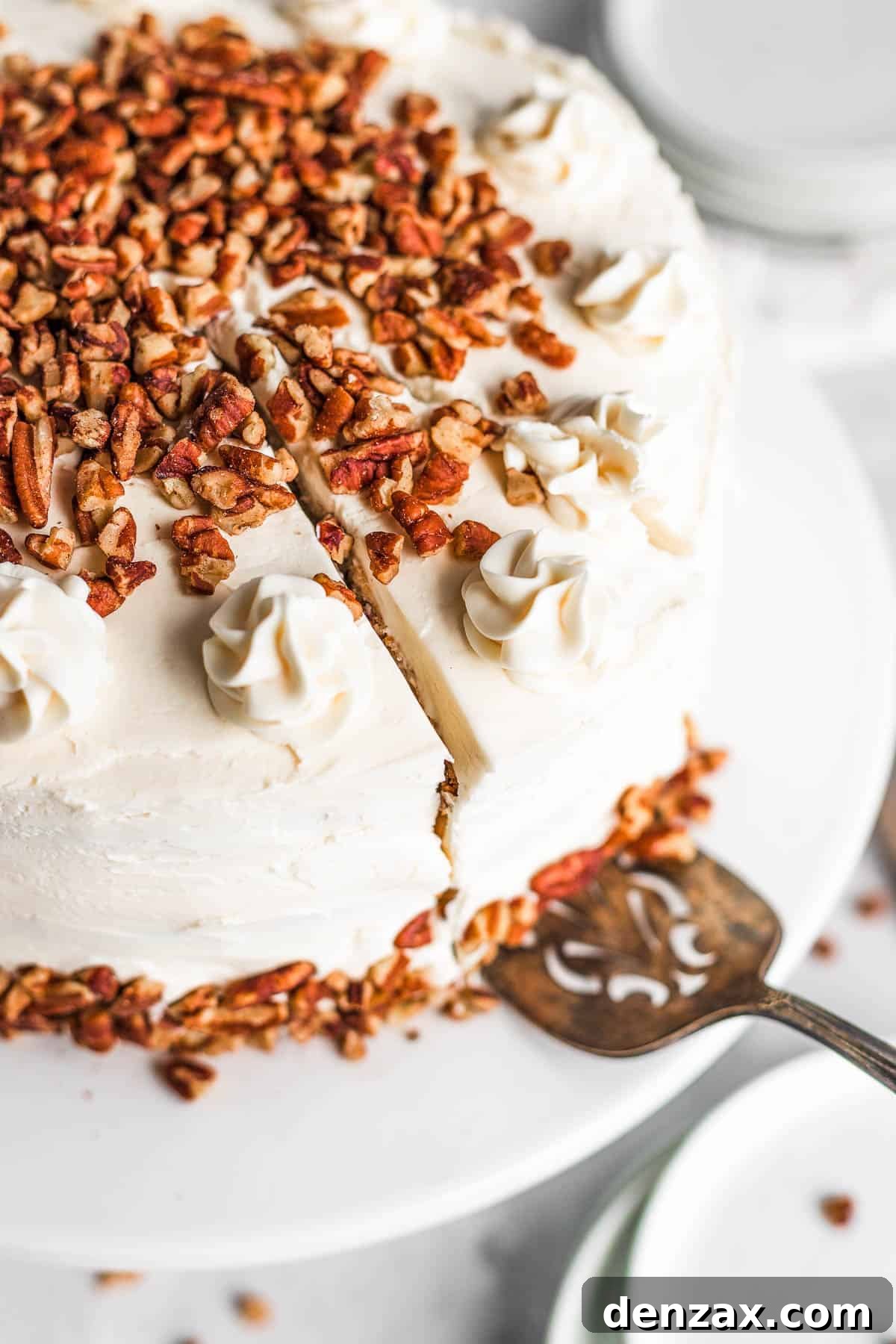 A Dessert Spatula Under a Piece of Hummingbird Cake Cut Out From the Full Cake