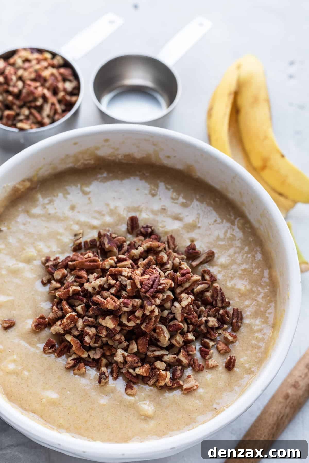 The Wet Ingredient Mixture in a Bowl with Crushed Pecans Floating on Top