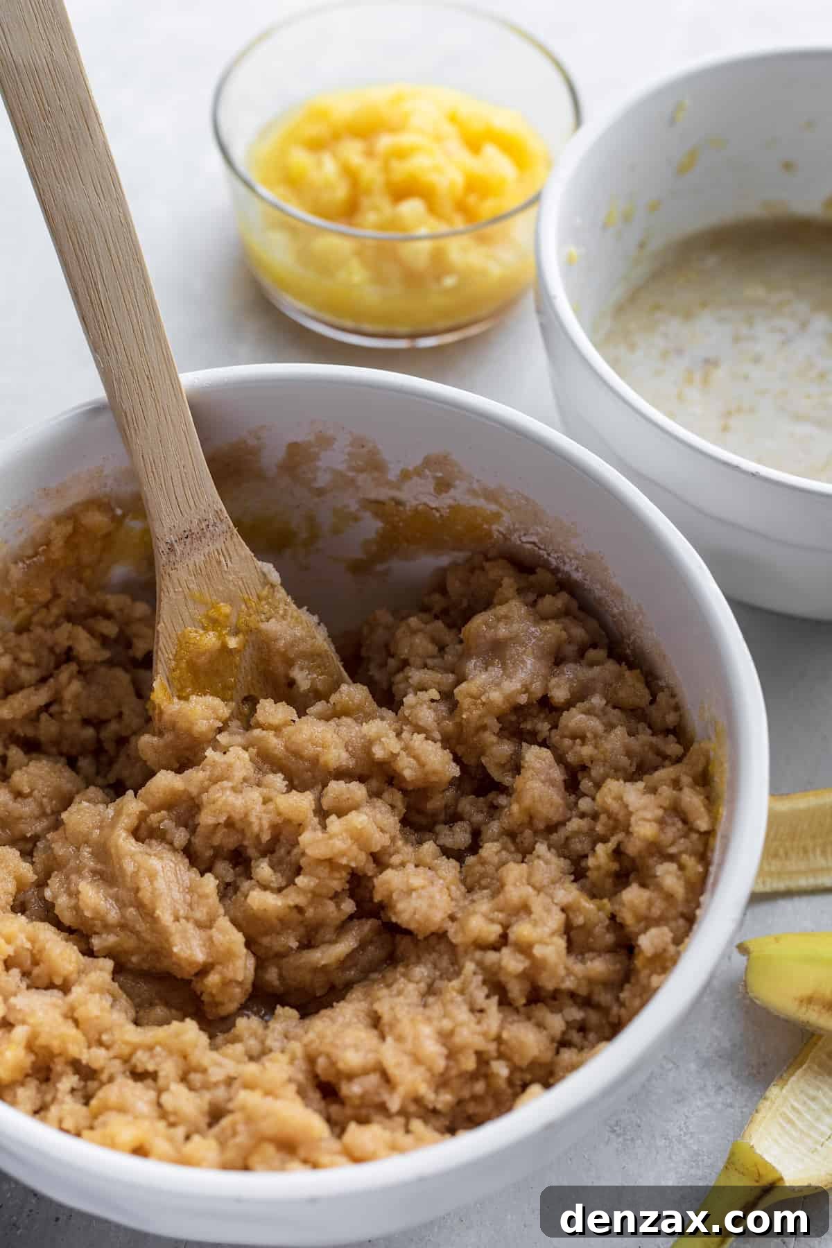 Hummingbird Cake Batter in a White Bowl on a Countertop Next to a Banana Peel