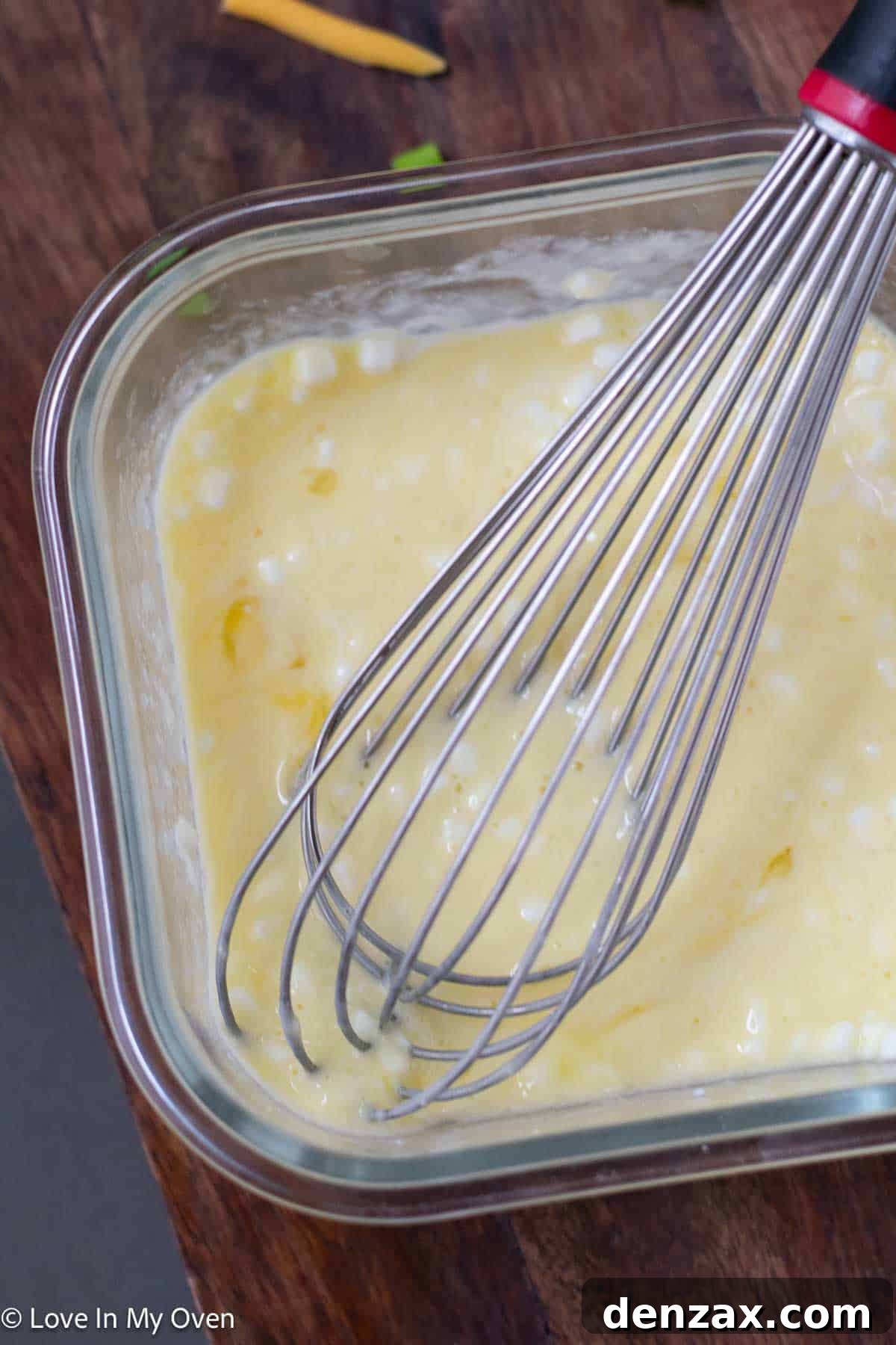Adding cottage cheese to eggs in a bowl