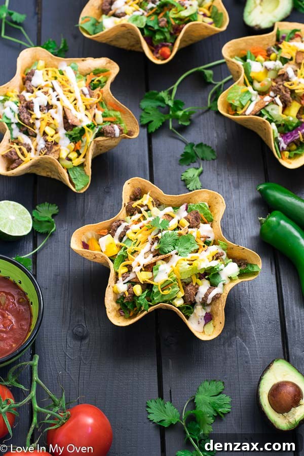 Delicious and simple taco salad with ground beef, crisp lettuce, and colorful vegetables, perfect for a quick and healthy meal. Served in an edible tortilla bowl.