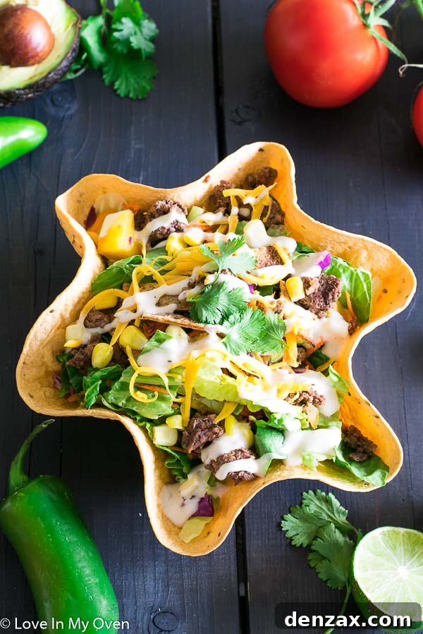 Close-up of a hearty taco salad with ground beef, fresh greens, and various toppings.