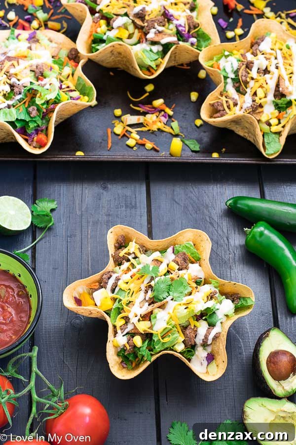 A vibrant and appetizing taco salad served in a crispy tortilla bowl, garnished with avocado and cilantro.