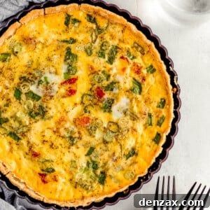 A Bacon Quiche Lorraine Beside a Gray Tablecloth and a Glass of Water