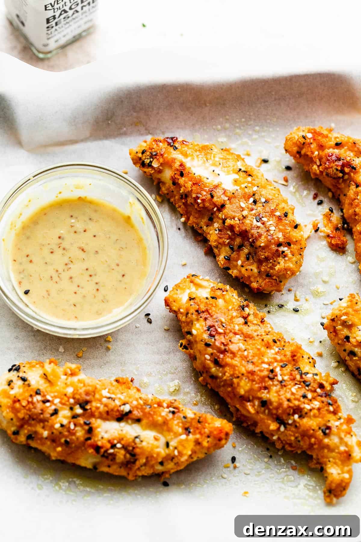 Everything Bagel Chicken Tenders on a white background served with dipping sauce