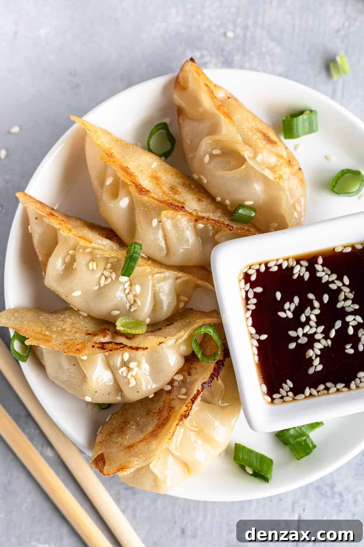 Crispy homemade chicken potstickers on a plate with dipping sauce