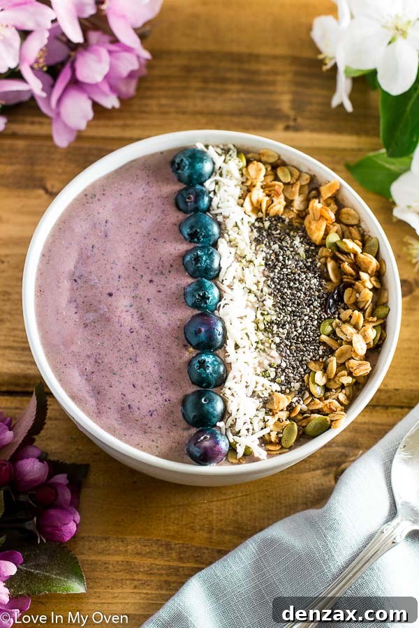 Vibrant cherry coconut smoothie bowl topped with fresh fruit and granola
