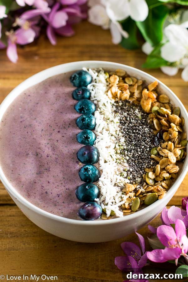 A beautifully arranged cherry coconut smoothie bowl with various toppings
