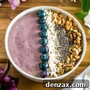 cherry coconut smoothie bowl in a white bowl with toppings