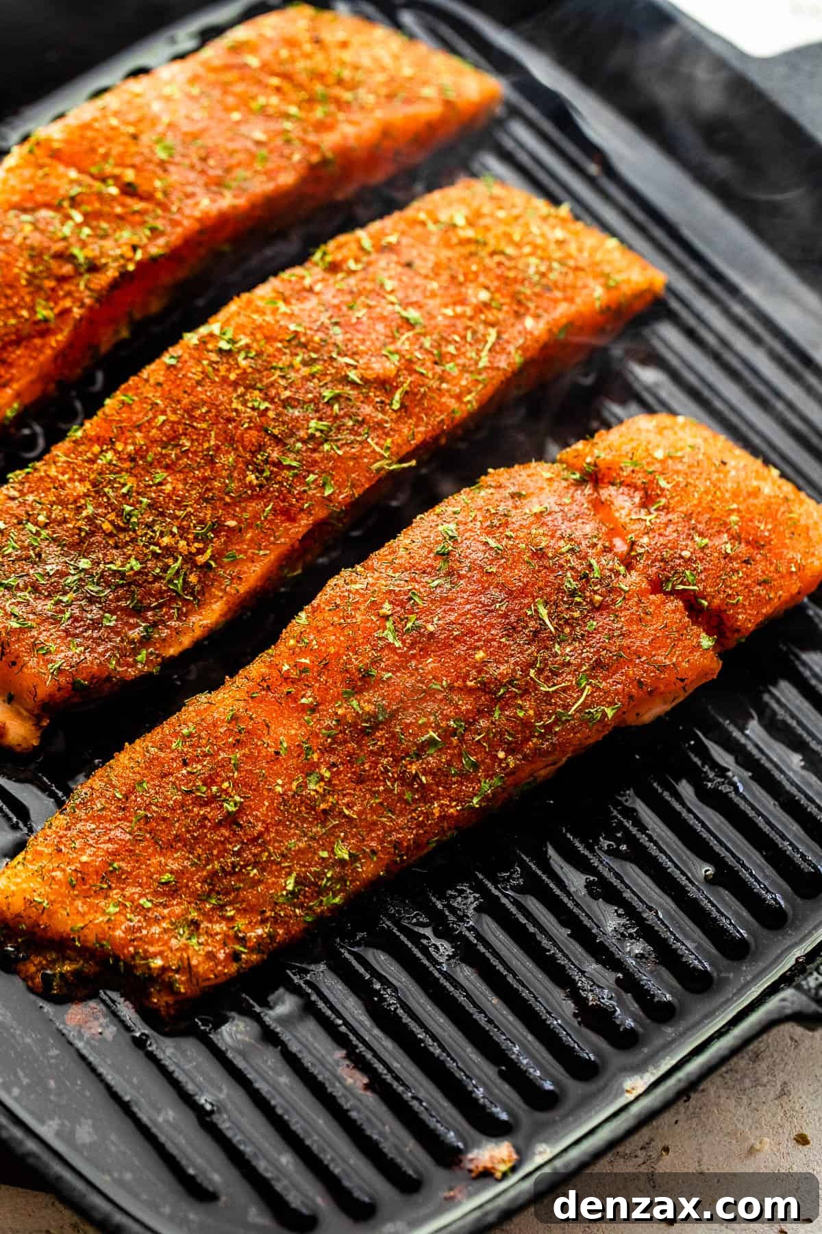 grilling salmon fillets on a black grill pan