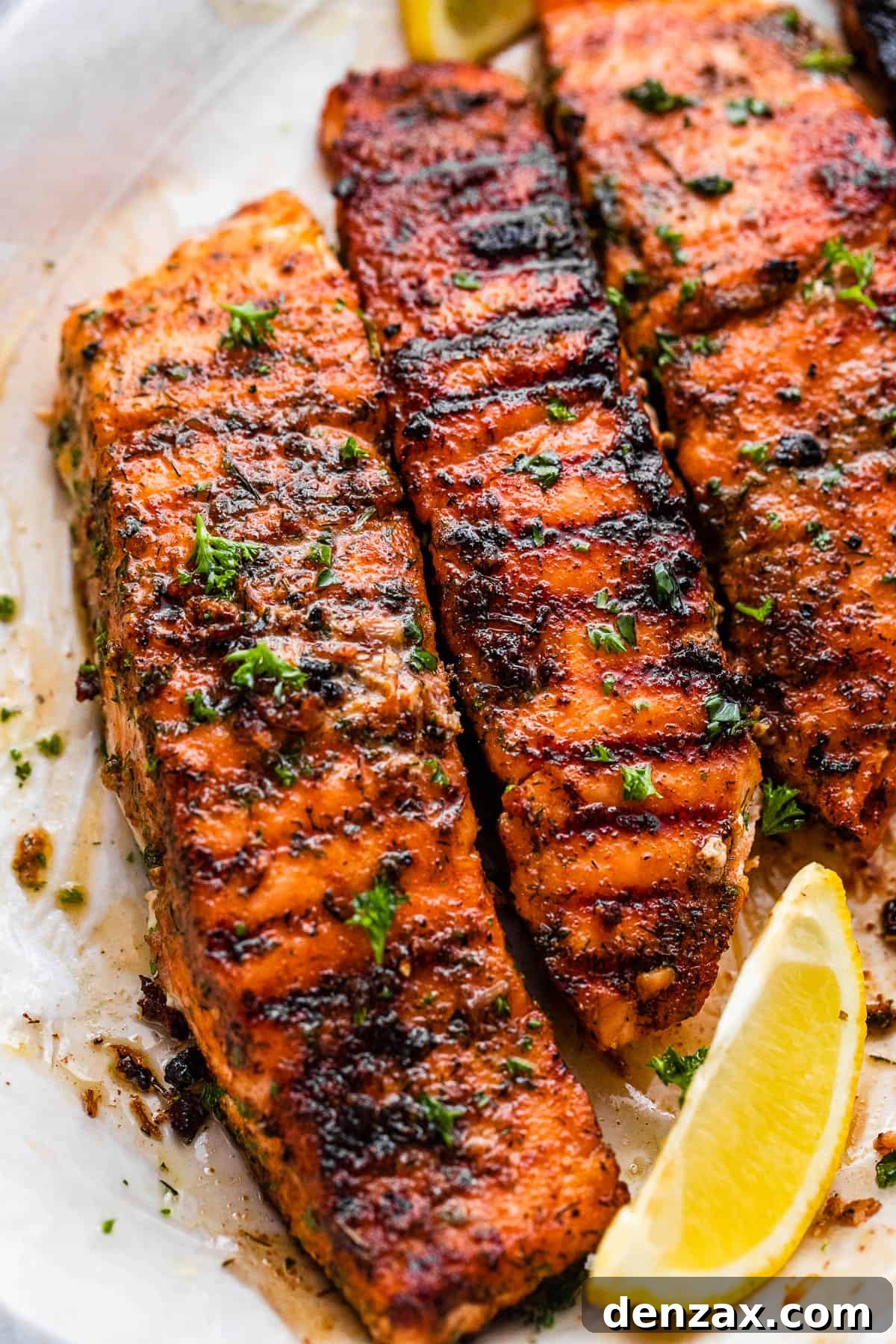 grilled salmon fillets on a plate with lemon wedges