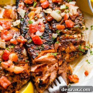 three grilled salmon fillets topped with tomatoes and onions