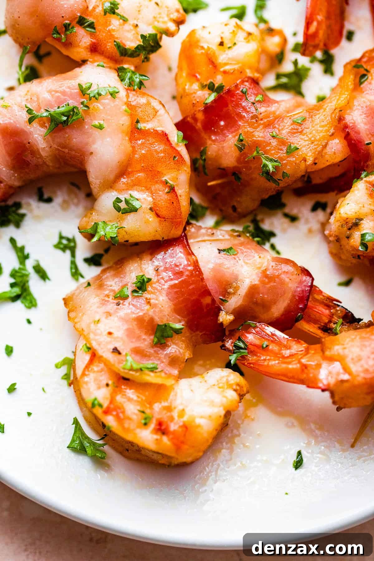 A vibrant platter of bacon-wrapped grilled shrimp, expertly arranged and garnished with fresh parsley, highlighting its crispy texture and golden hue.