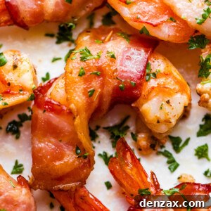 up close photo of bacon wrapped shrimp arranged on a white plate and garnished with parsley