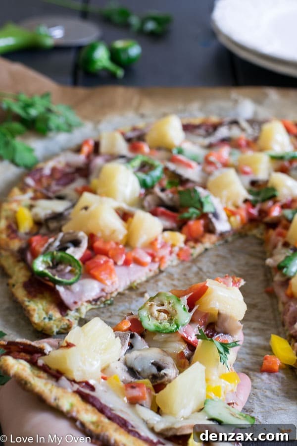 Full gluten-free zucchini pizza on a pan, sliced and ready to serve.