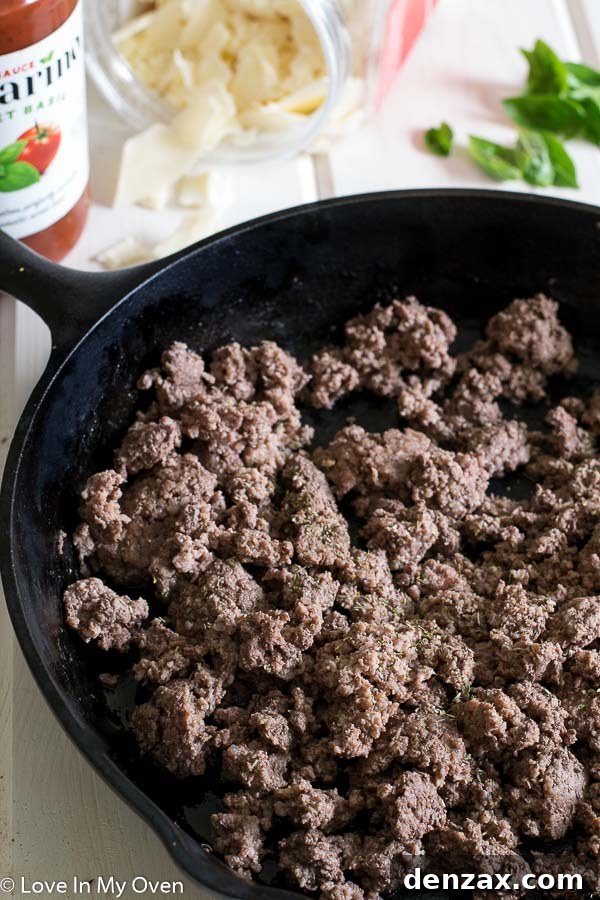 Raw ingredients for skillet pasta including uncooked linguine, ground beef, bell peppers, and mushrooms, ready to be cooked in a skillet.