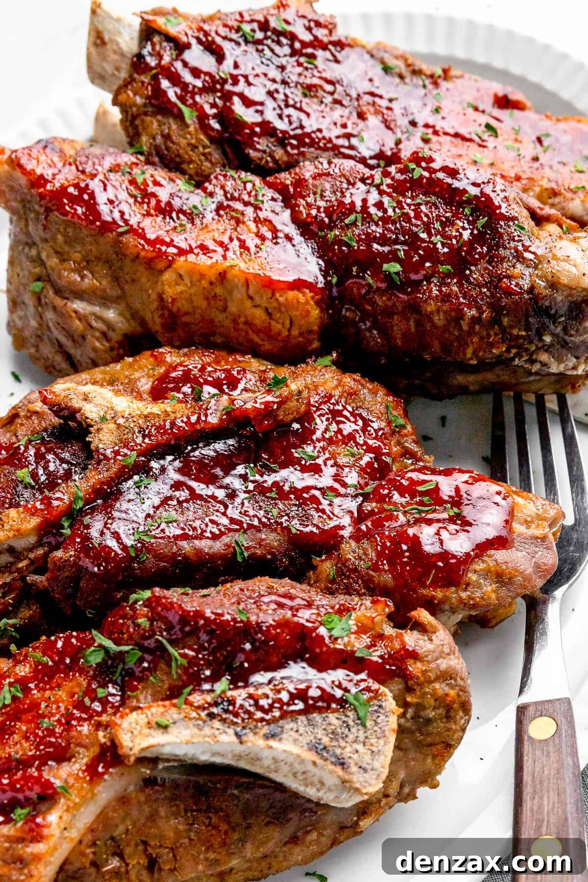 Side shot of Instant Pot Ribs on a White Serving Platter with a Small Salad in the Background, showcasing the perfect glaze and tenderness.