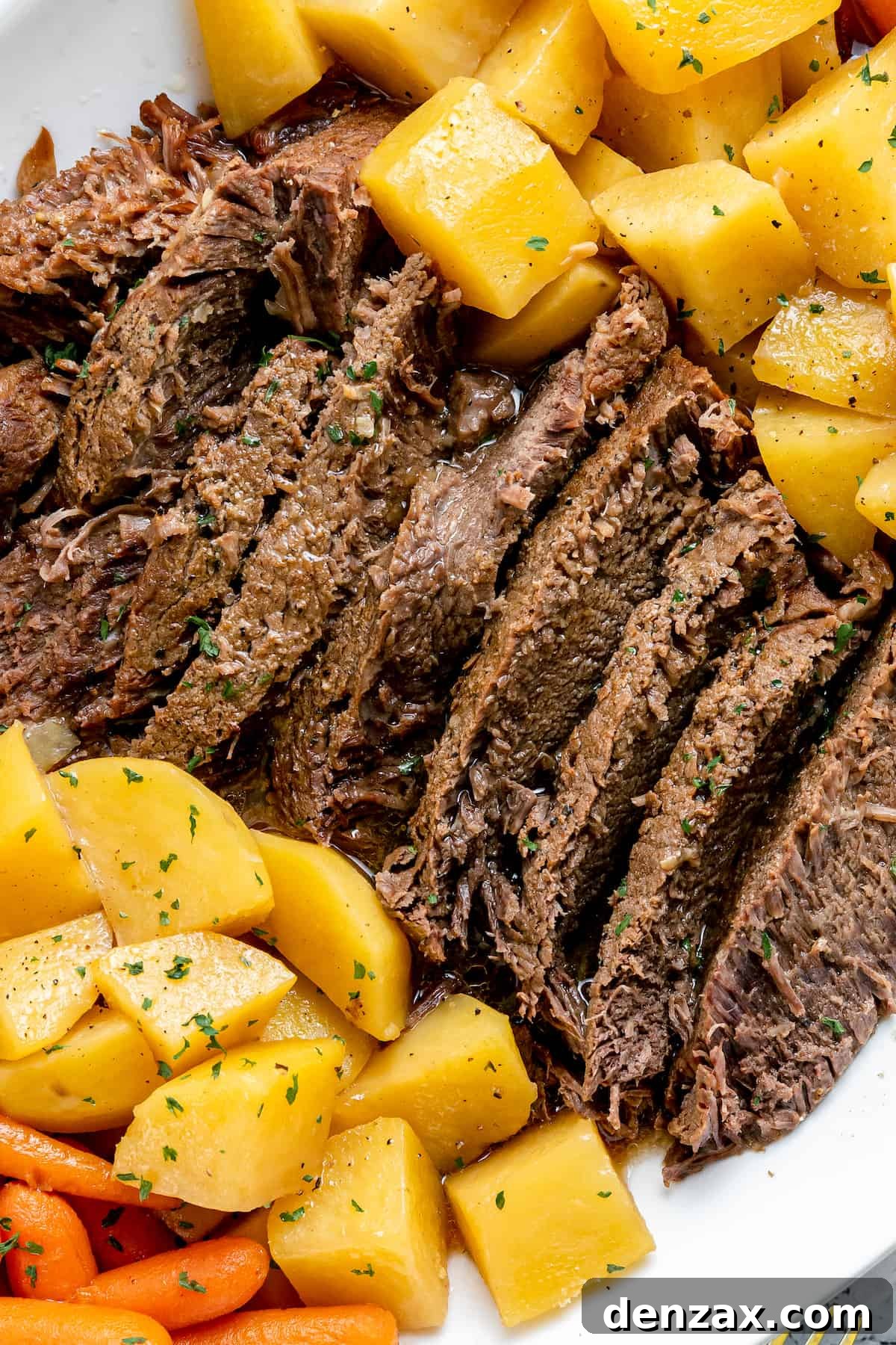 Hearty Instant Pot Pot Roast served on a white plate with tender potatoes and carrots.