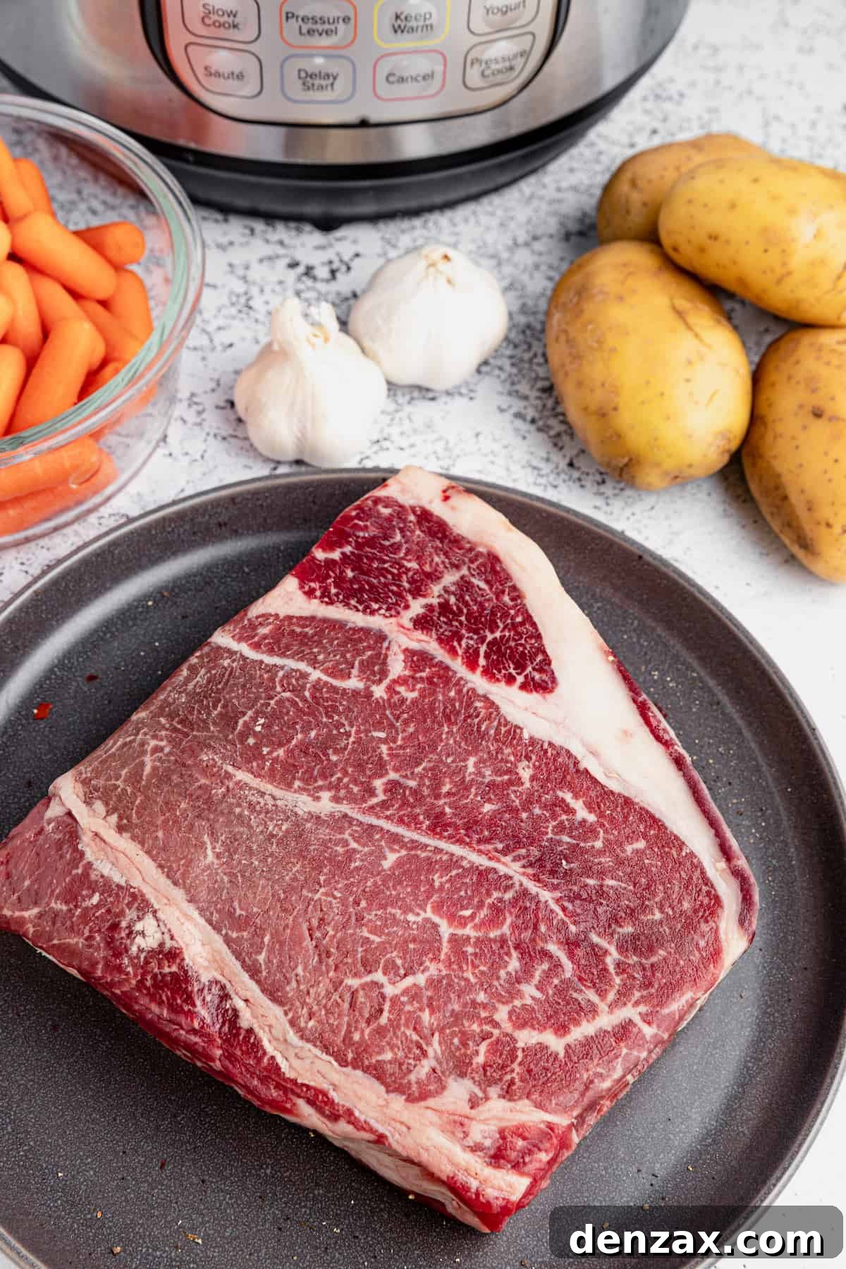 Preparing the ingredients: steak, potatoes, garlic, and carrots for the Instant Pot Pot Roast.