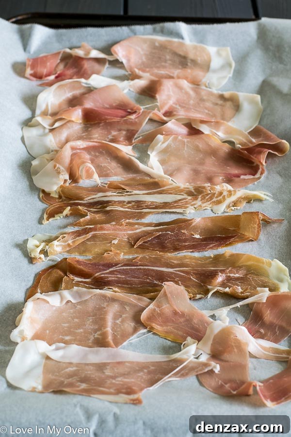 Crispy prosciutto baking on a parchment-lined sheet, a perfect topping for butternut squash pasta