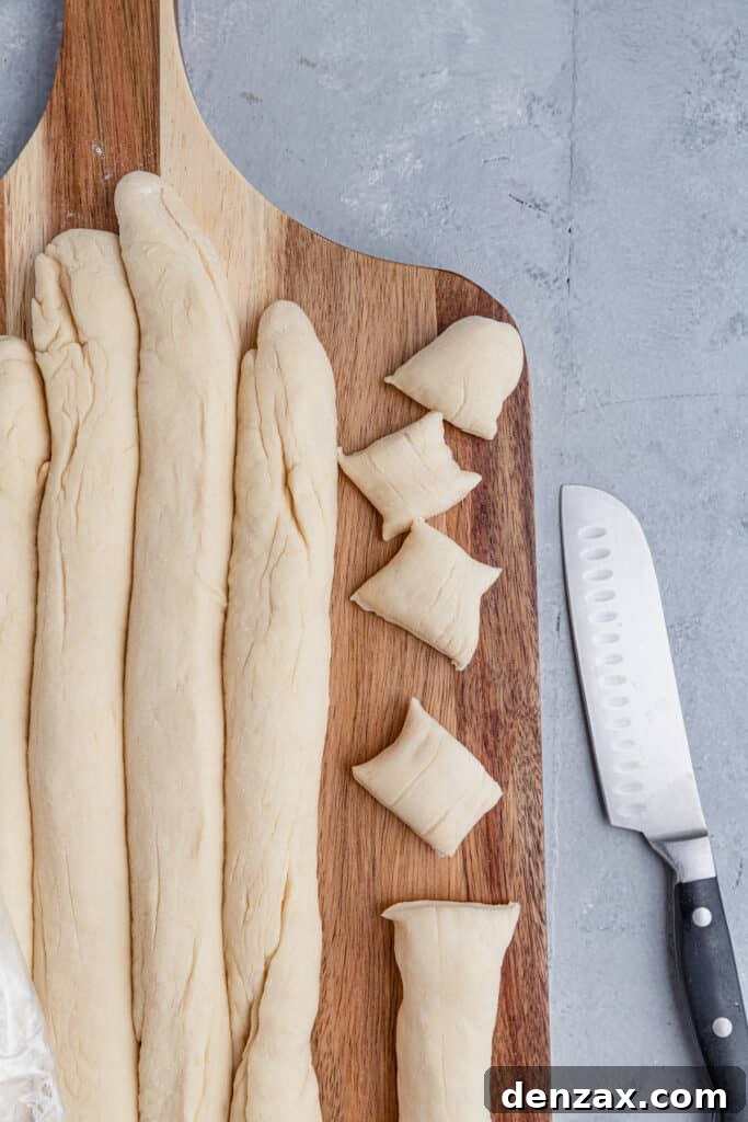 Ropes of pretzel dough being cut