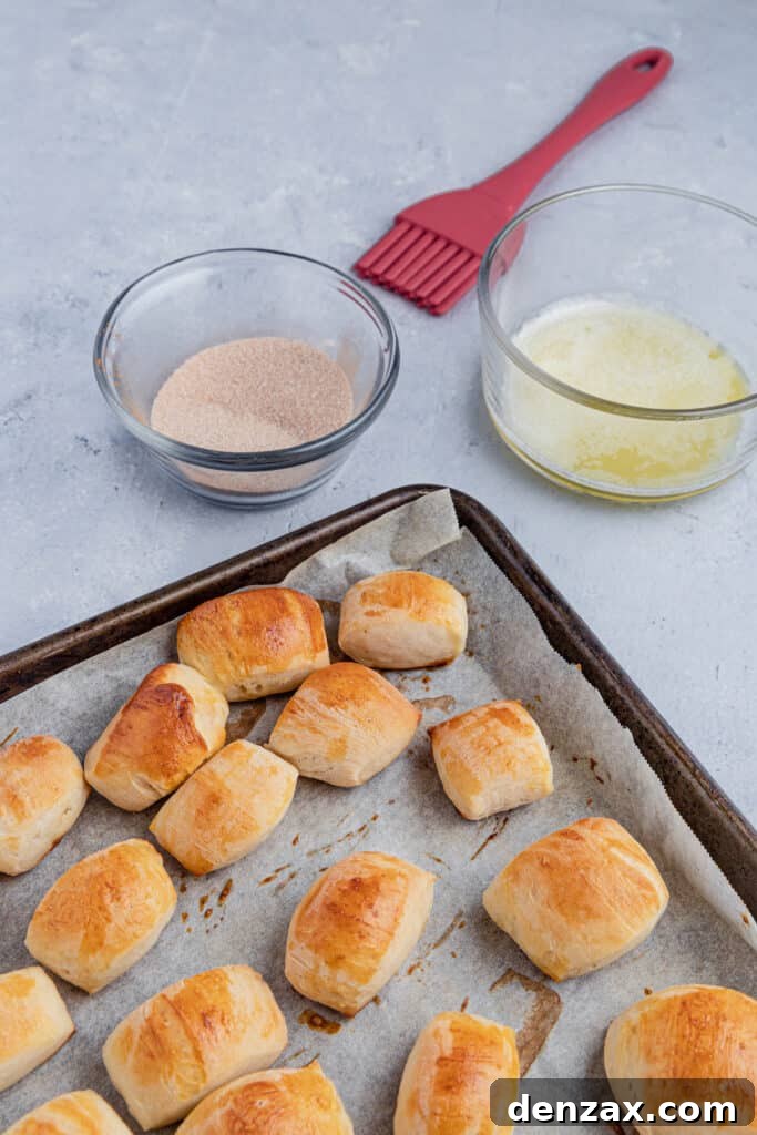 Baked pretzel bites with a bowl of butter and a bowl of cinnamon sugar