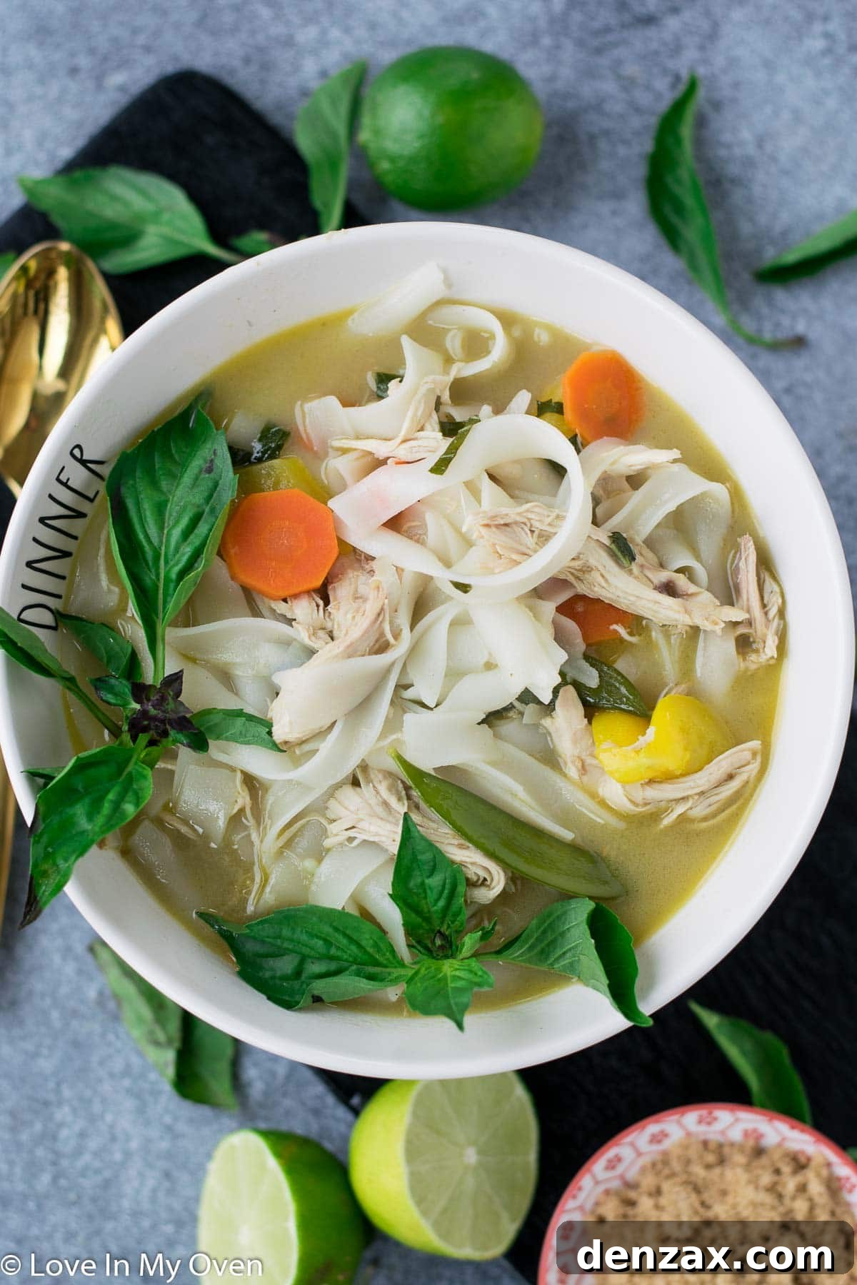 A close-up of Spicy Thai Chicken Noodle Soup with fresh ingredients.