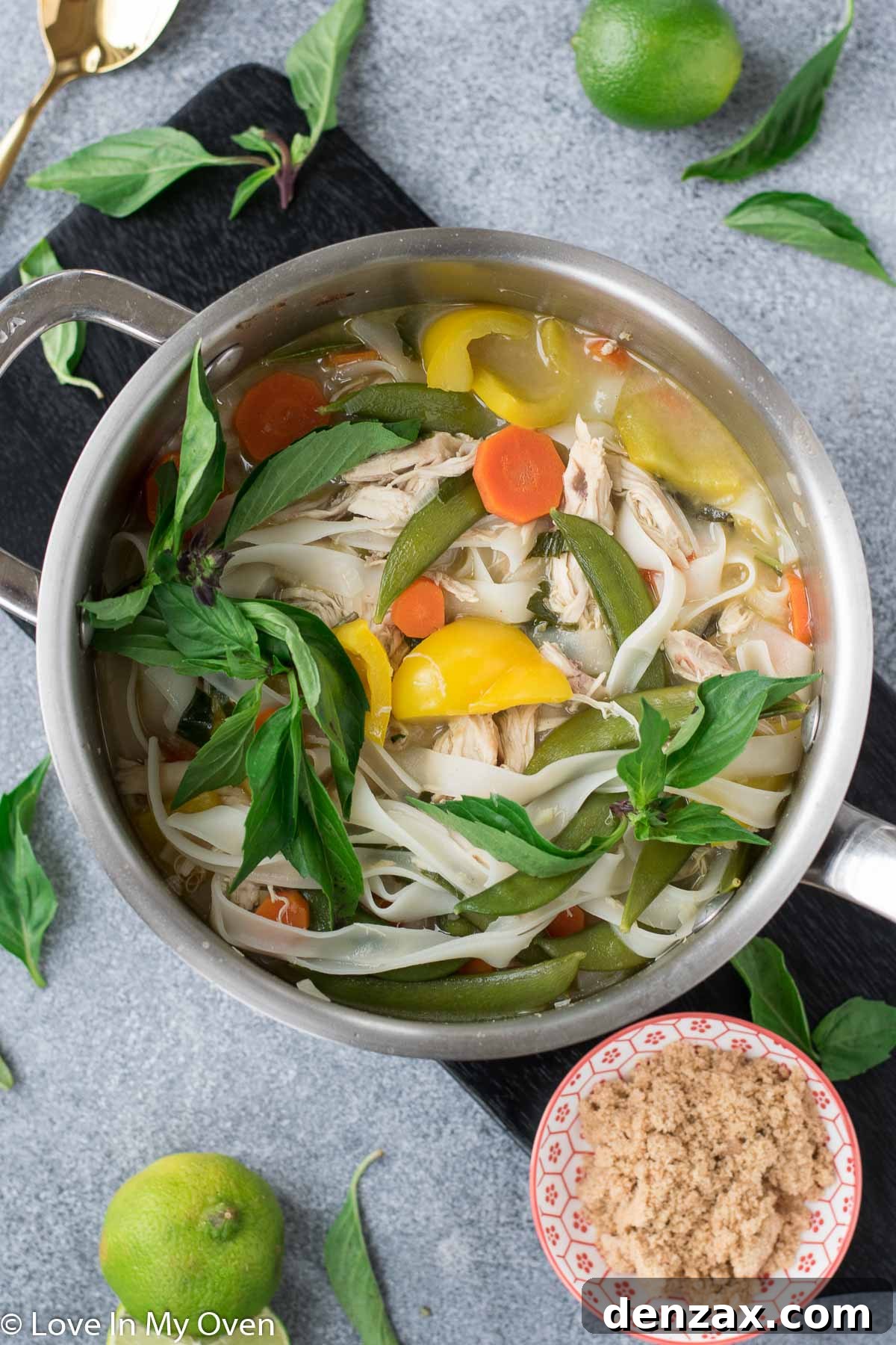 Spicy Thai Chicken Noodle Soup garnished with fresh herbs.