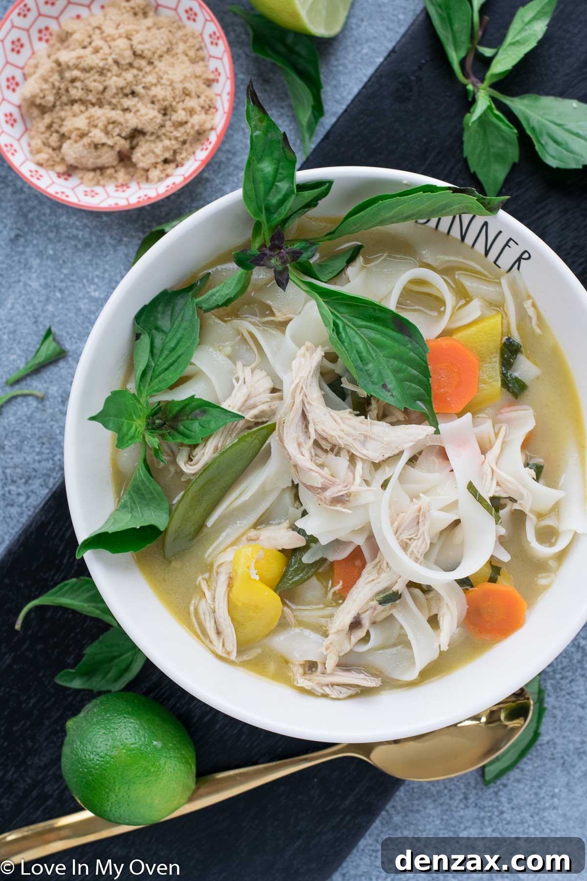 A bowl of Spicy Thai Chicken Noodle Soup with chopsticks.