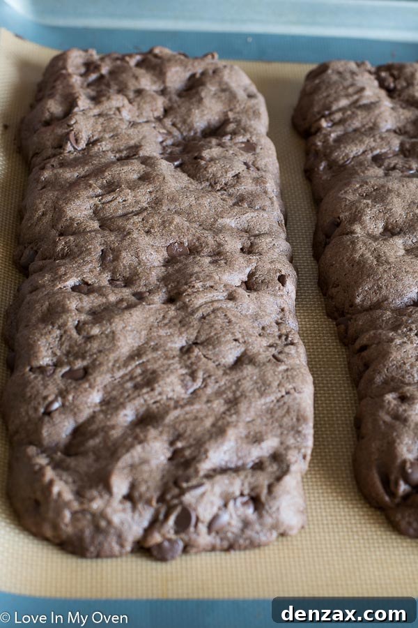 Slicing warm chocolate peppermint biscotti logs diagonally