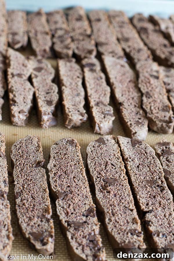 Arranging sliced chocolate peppermint biscotti on a baking sheet for the second bake