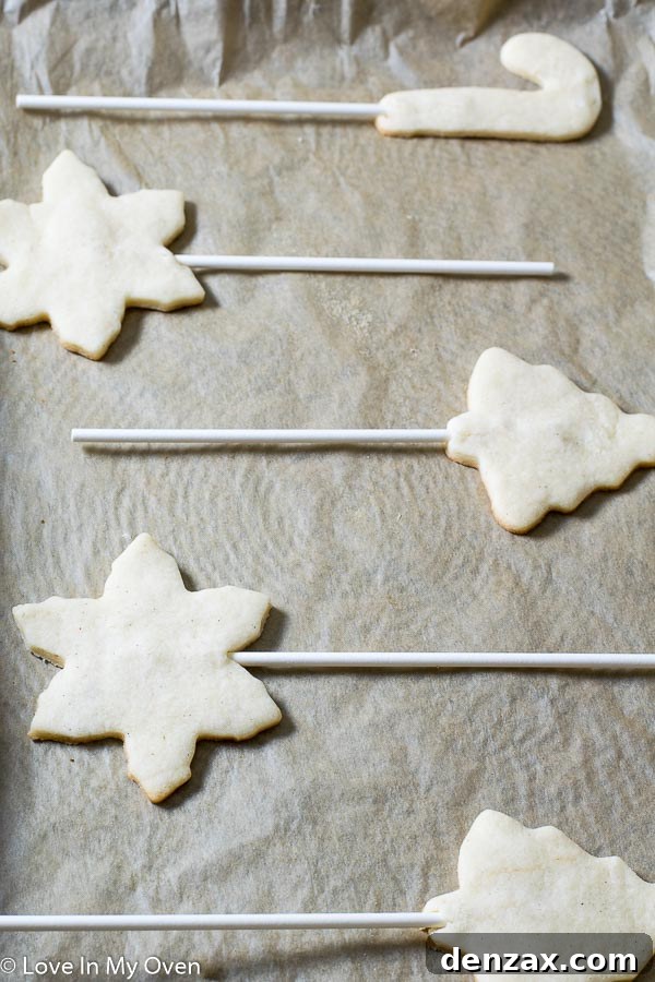 Festive Cookie Pop Treats 4 Freshly baked vanilla bean cookies with lollipop sticks inserted, cooling on a baking sheet