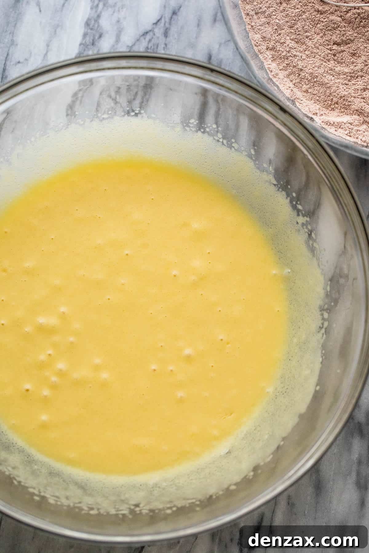 Bowl of wet ingredients for chocolate zucchini bread batter, showcasing the smooth mixture