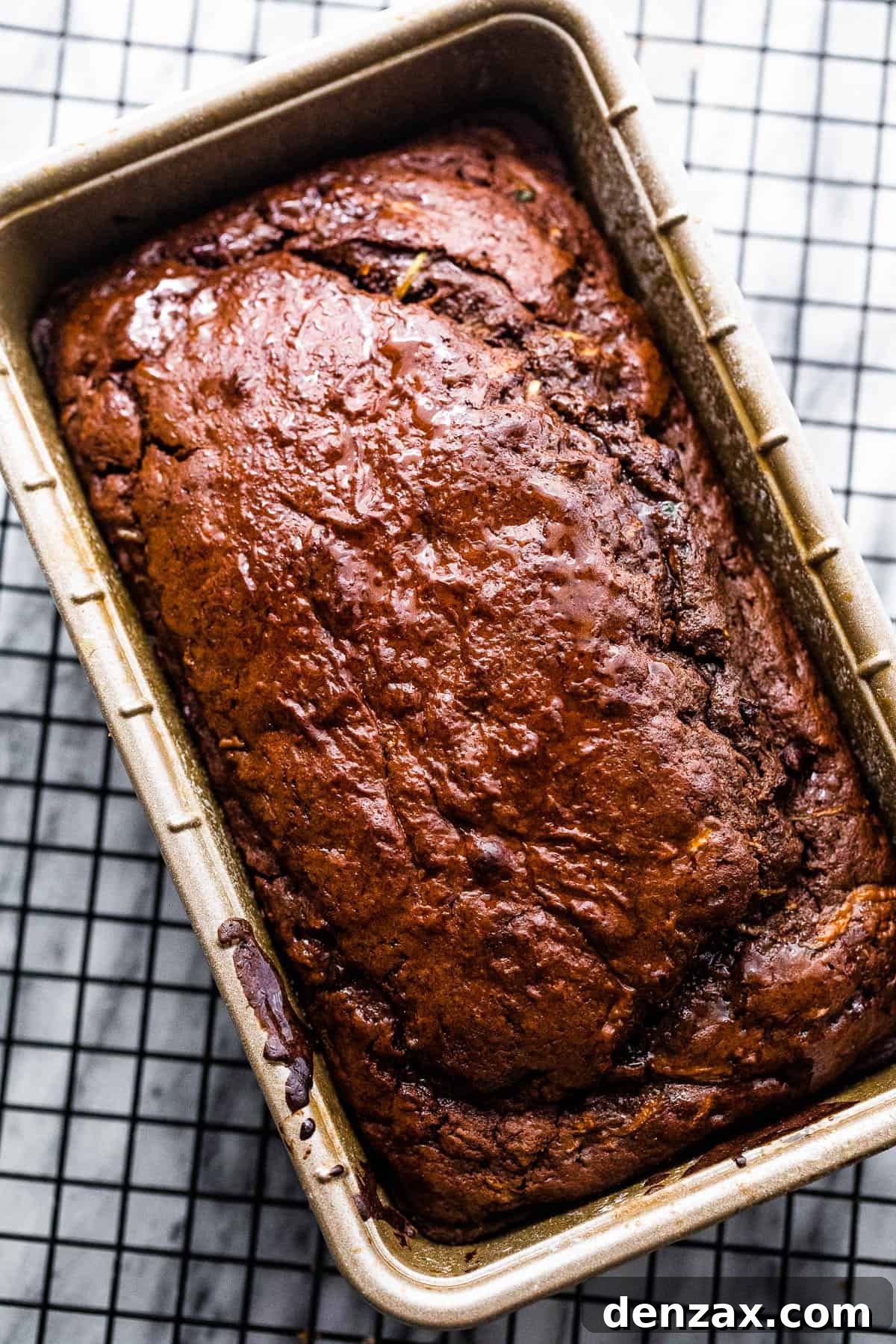 Freshly baked chocolate zucchini bread cooling on a wire rack in a loaf pan
