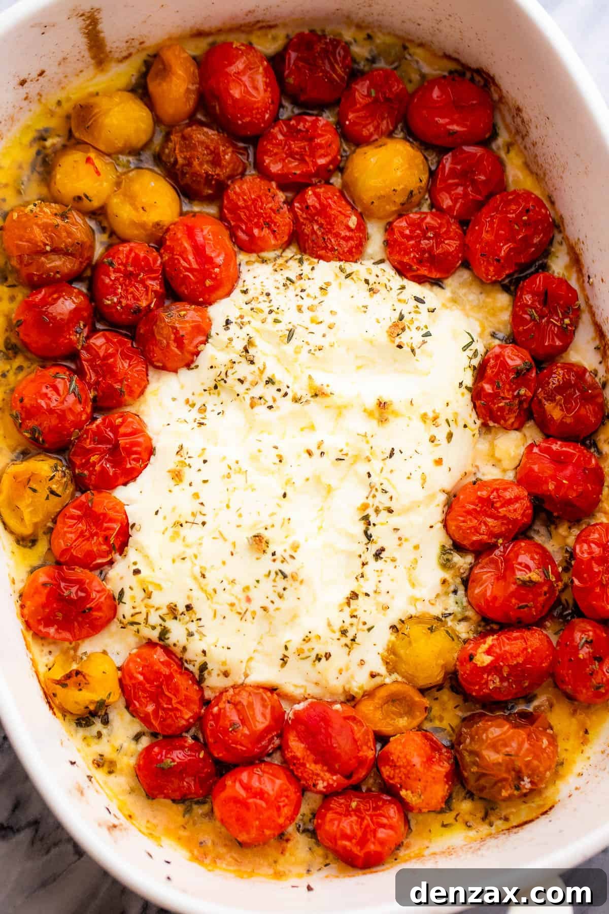 a baking dish with block of cream cheese with cherry tomatoes around it